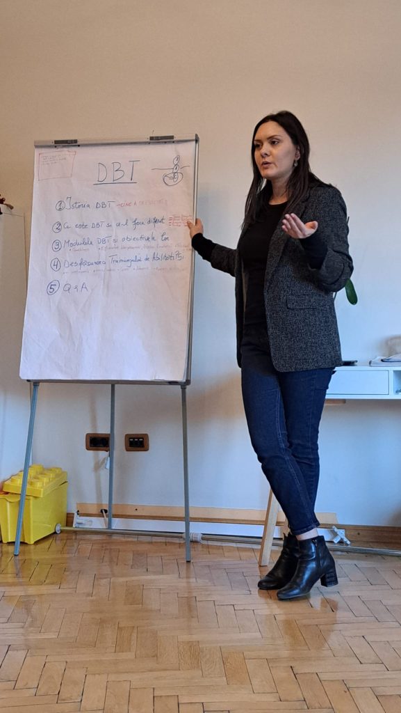Roxana Alistar-Blehuiu predând un modul DBT la flipchart, în cadrul unui training de abilități